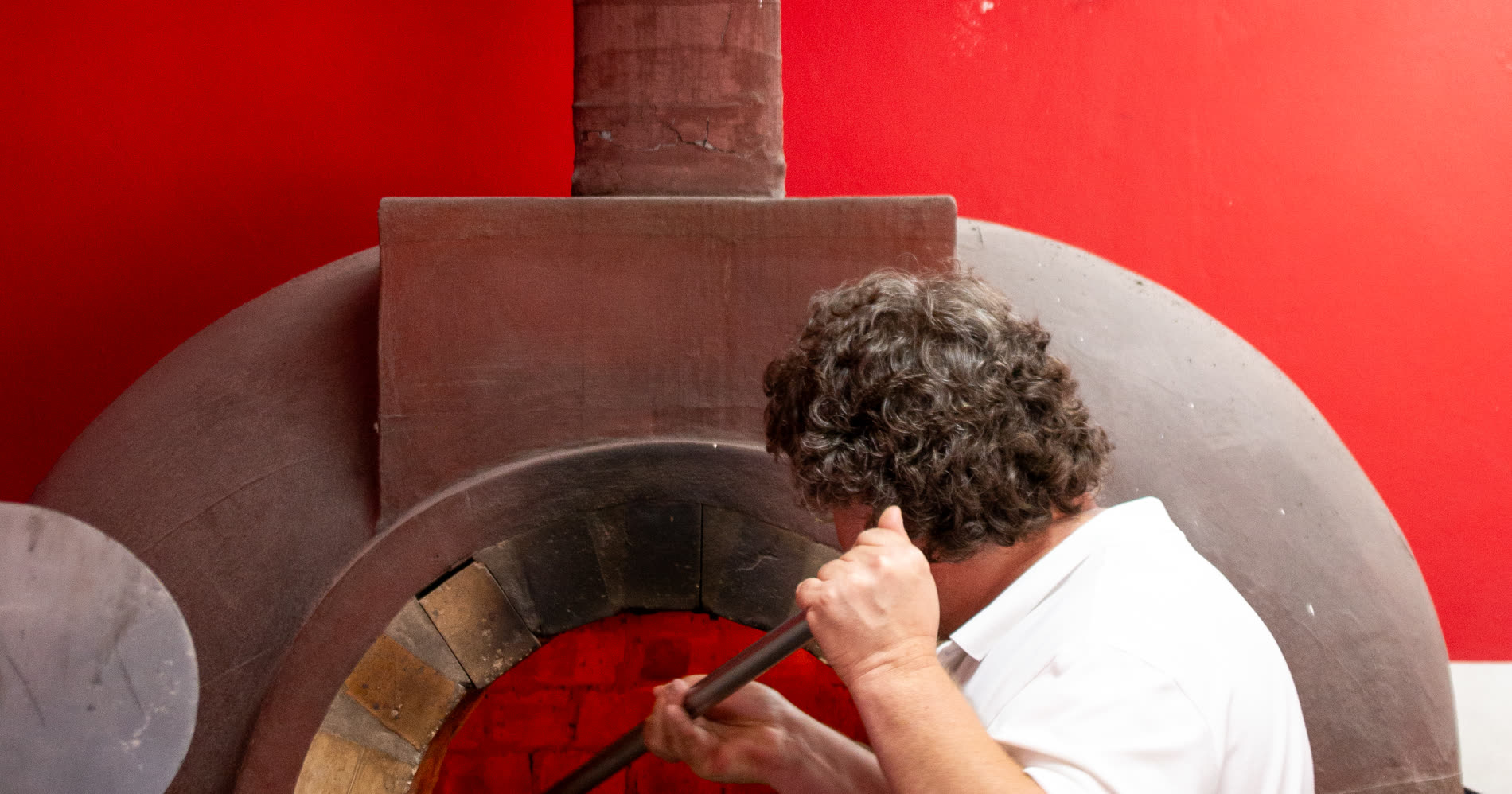 The pizzaiolo turning a pizza inside the woodfired oven at Lorenzo's